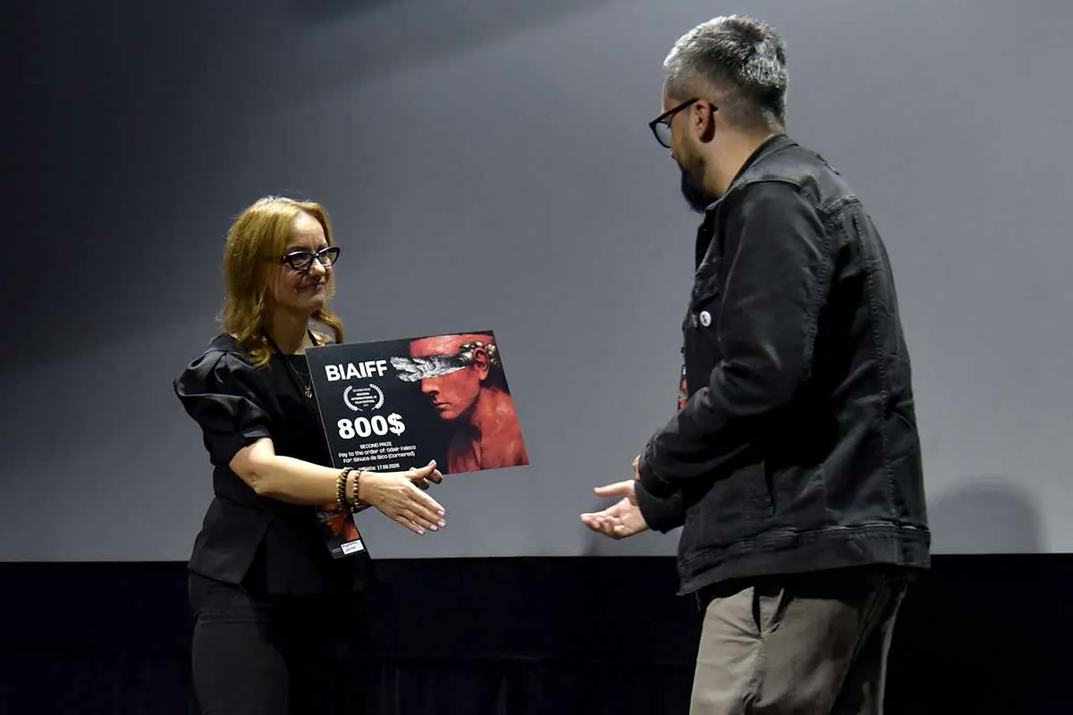 A prize board being handed over on the Kino Regis stage